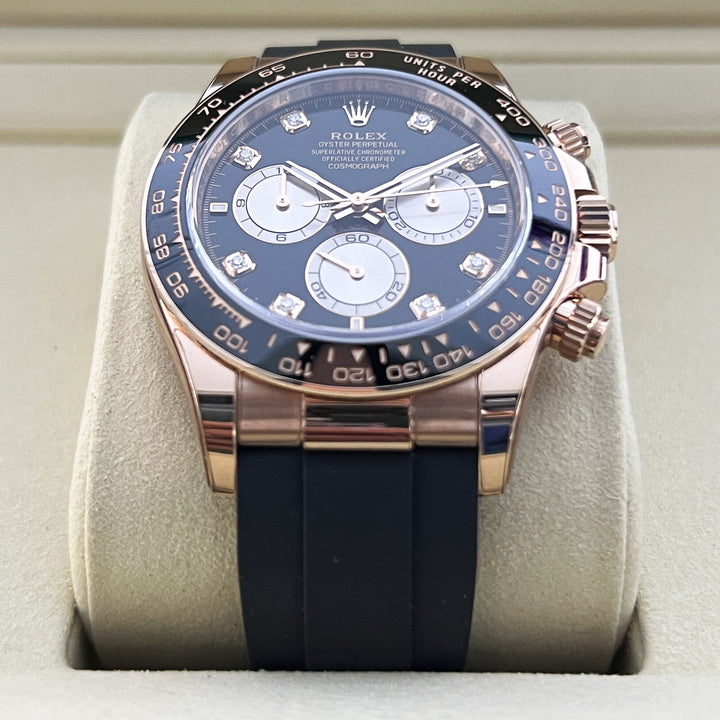 Luxury watch with blue dial and black strap on a white cushion