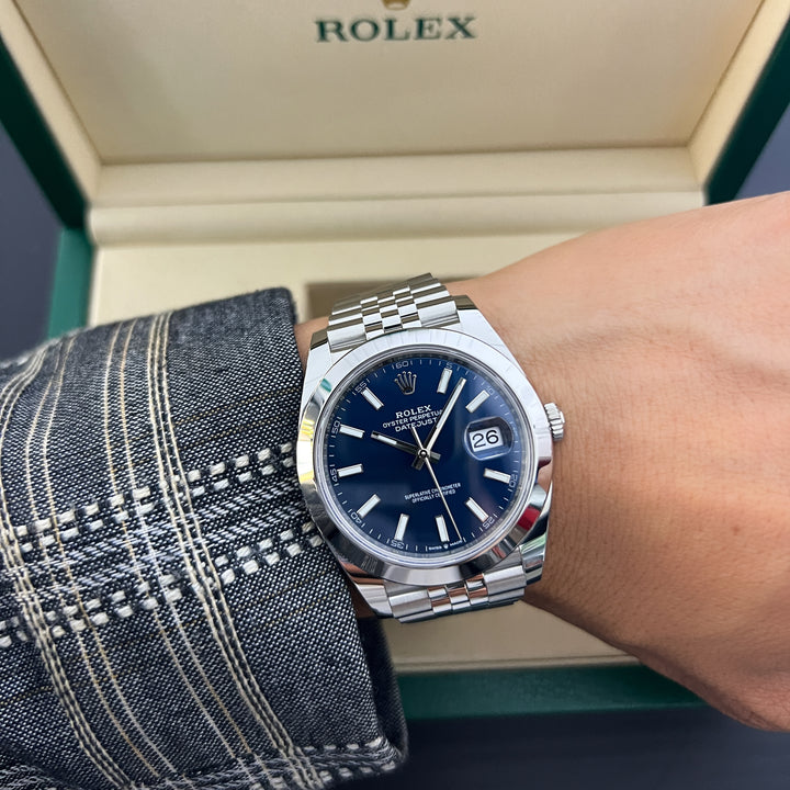 Rolex watch on a wrist with a visible Rolex box in the background