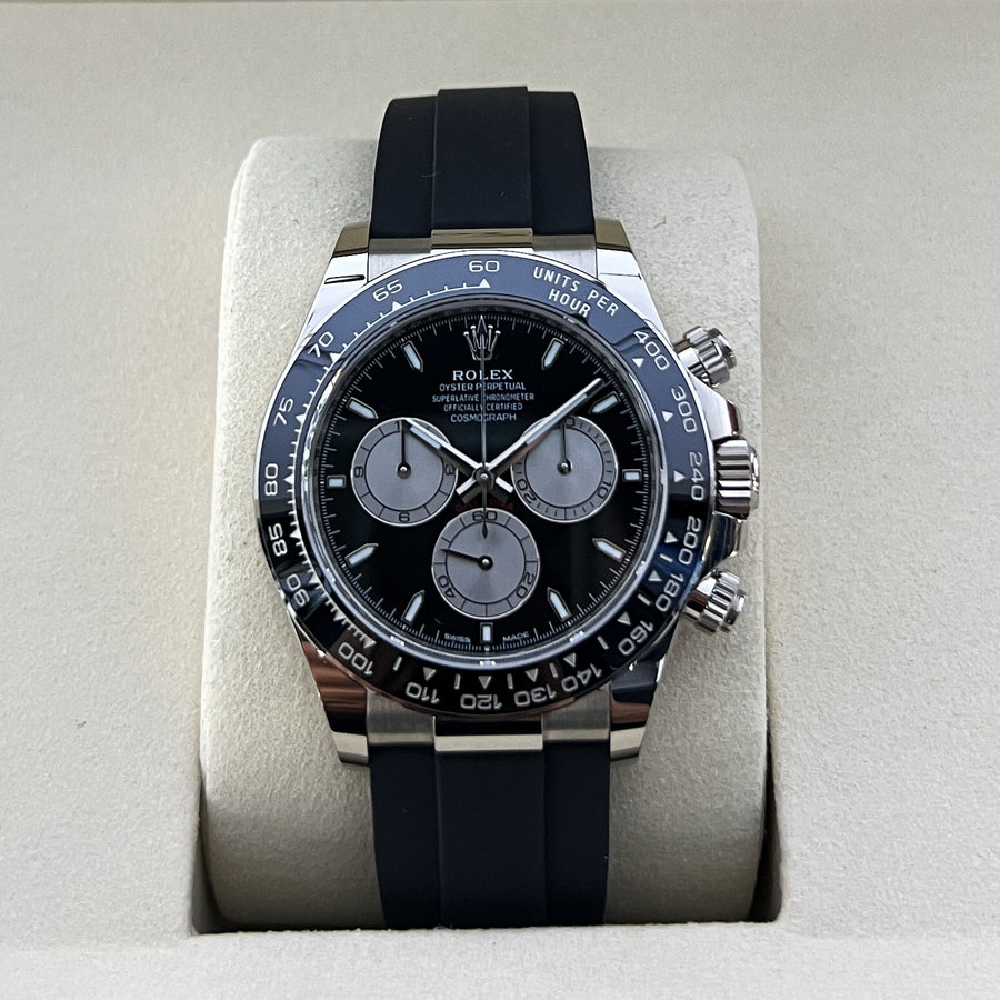 Rolex watch with black rubber strap on a light gray background