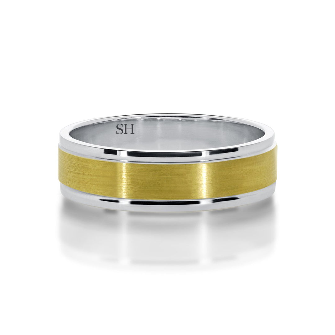 Men's two tone wedding band with central satin finish R12-077B-W0110. This classic 18k yellow and white gold men's wedding ring has polished white gold rounded edges with a yellow gold flat centre profile and a satin finish applied. The ring has an overall subtle look with a beautiful contrast from the reflective polished edges. The ring has a wide uniform width and a bold solid feel to it.